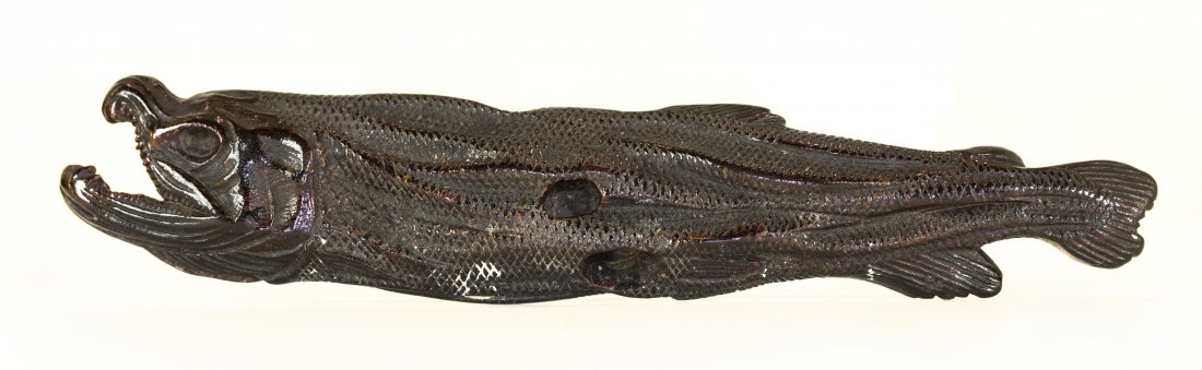 JAPANESE UMIMATSU NETSUKE , Meiji Period (1868-1912): PROPERTY FROM A FLORIDA COLLECTION JAPANESE CARVED WOOD UMIMATSU NETSUKE Early 19th Century. Of a himono (desiccated fish), lying on its side, its mouth open and its skin, carved with neat scales adhe