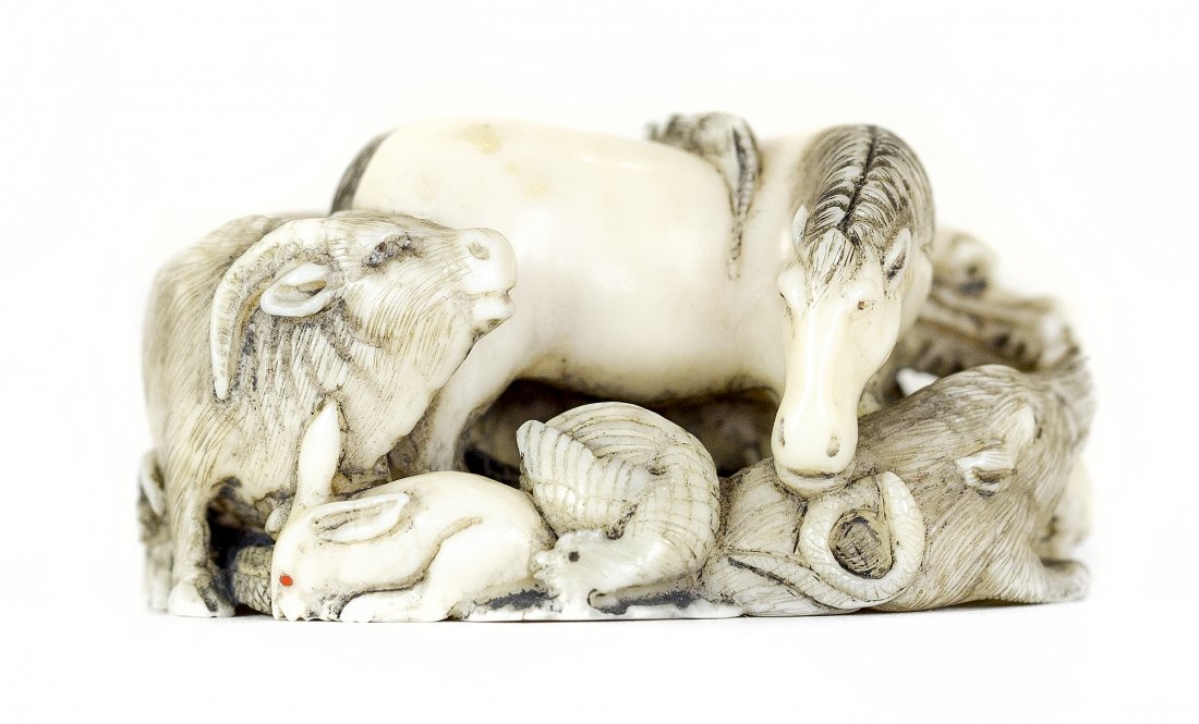 CARVED IVORY NETSUKE: PROPERTY FROM A FLORIDA COLLECTION CARVED IVORY NETSUKE Signed. Of the Junishi (Twelve Zodiac Animals), the animals clustered together in a compact grouping. Length 1 3/4 inches.