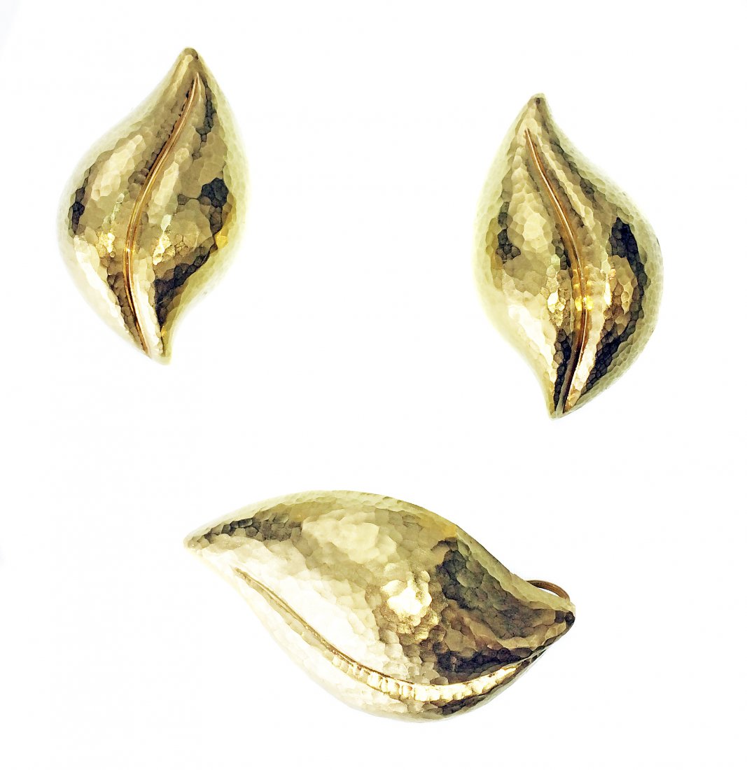 TIFFANY & CO. 18 KARAT YELLOW GOLD 3-PC SUITE: TIFFANY & CO. 18 KARAT YELLOW GOLD 3-PC SUITE Signed, Designed by Paloma Picasso. Comprising a pair of ear clips and matching brooch/pendant. Each in the form of leaf with hammered design. Stamped T&C