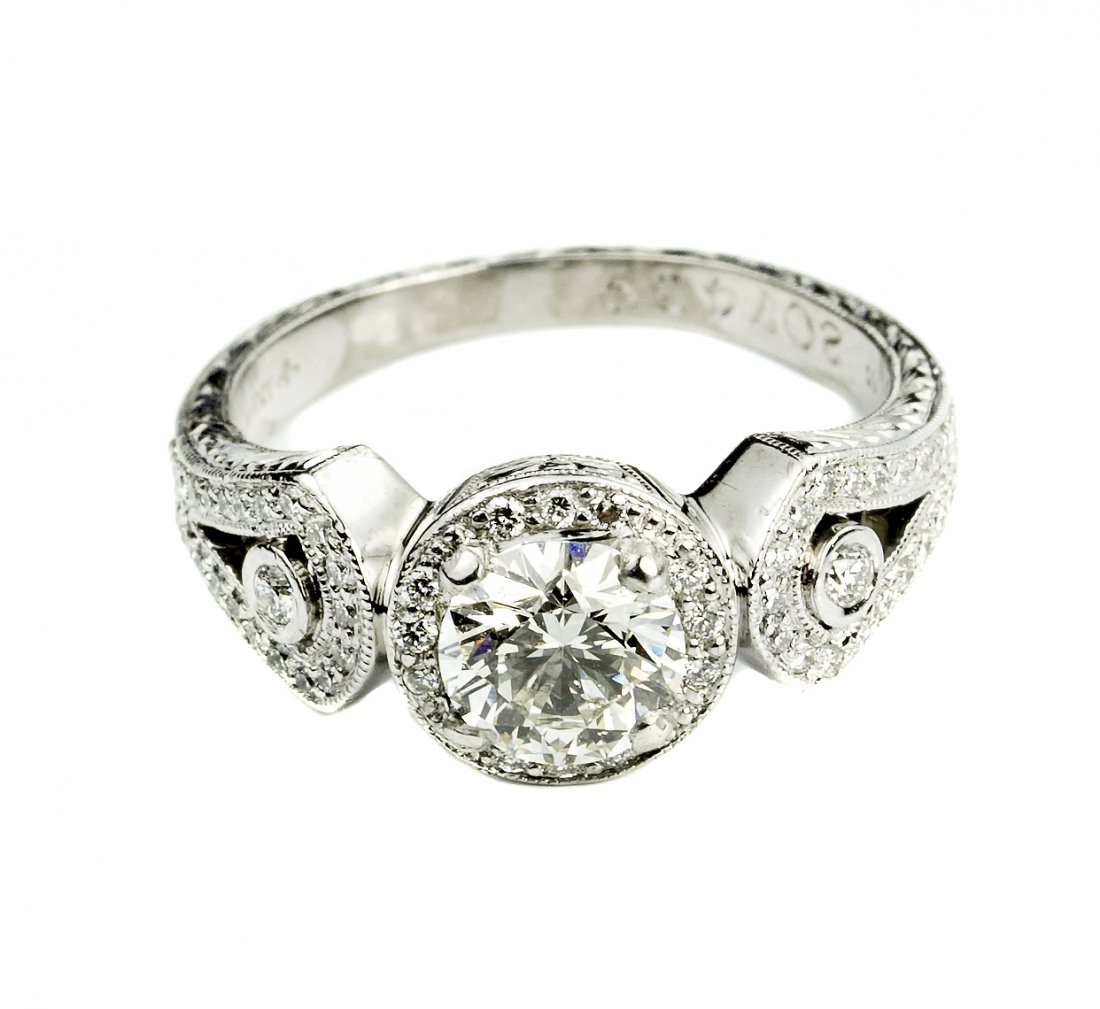 MICHAEL BEUDRY DIAMOND RING: MICHAEL BEUDRY DIAMOND RING Stamped Beaudry, and number 207439. Set with one round cut diamond, weighing approximately 1.04 carats, and surrounded by pave set diamonds. Mounted in platinum.