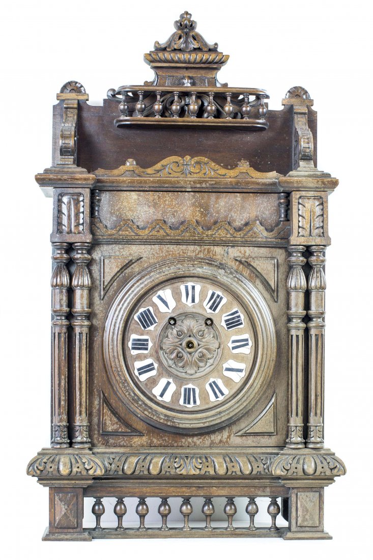 TUDOR STYLE WALNUT WALL CLOCK: NO RESERVE - NO MINIMUM TUDOR STYLE WALNUT WALL CLOCK Carved with foliate and architectural elements. Lacking clock hands, movement in need of repair. Height 33 in. Width 18 in. Depth 5 ½ in.