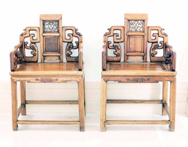 PAIR OF CHINESE HONG-MU ARMCHAIRS, CIRCA 1920: PAIR CHINESE CARVED HONG-MU ARMCHAIRS, circa 1900, the backrest carved in openwork, flanked by archaic style scroll-form back and side rails, the rectangular seat is set above a narrow waist above the