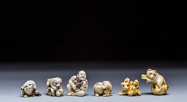SIX CARVED IVORY NETSUKE: SIX CARVED IVORY NETSUKE The first netsuke of three puppies and a dog, the second netsuke of a dog with a frog, the third netsuke of a boy with puppy, the fourth netsuke of a fox, the fifth netsuke of