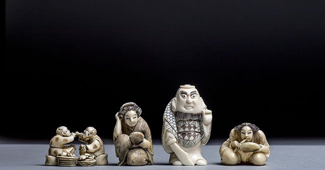 FOUR CARVED IVORY NETSUKE: FOUR CARVED IVORY NETSUKE The first netsuke of a lady seated with her legs crossed, the second netsuke of a man standing, the third netsuke of a seated lady, the fourth netsuke of a lady holding a fan