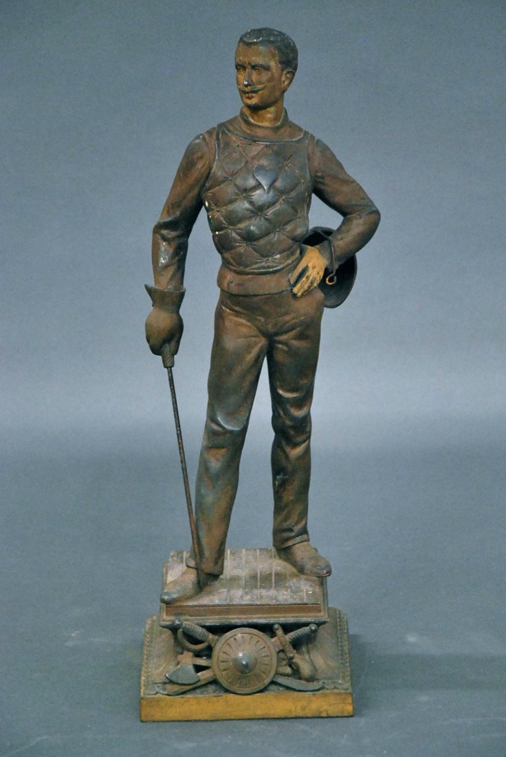 PATINATED METAL FIGURE OF A GENTLEMAN WITH HIS RAPIER: PATINATED METAL FIGURE OF A GENTLEMAN WITH HIS RAPIER Wearing his padded fencing vest, with trophy below. Height 17 in.