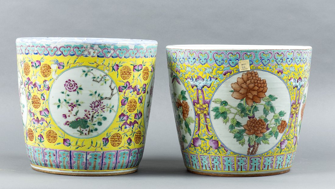 2 SIMILAR CHINESE FAMILLE JAUNE PORCELAIN JARDINIERIES: TWO SIMILAR CHINESE FAMILLE ROSE PORCELAIN JARDINIERES(Late 19th Century) Of cylindrical form, reserved with panels of flowers and insects, dotted by Buddhist symbols on a yellow ground. Height 13 in.