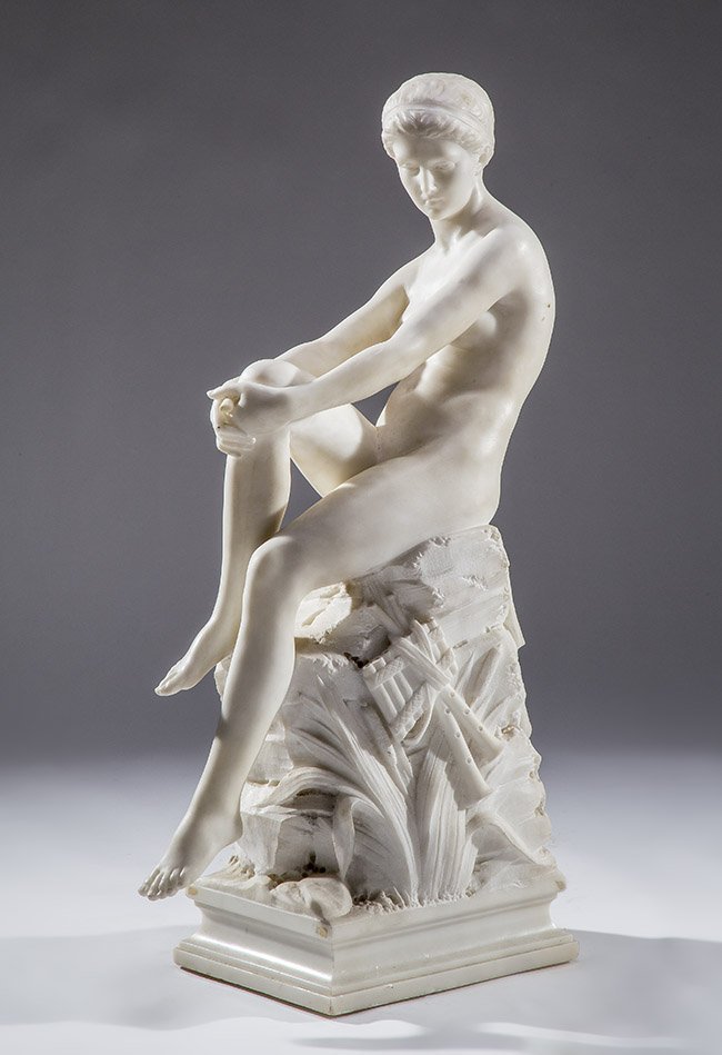 ITALIAN CARVED MARBLE OF A FEMALE NUDE, CIRCA 1900: ITALIAN CARVED MARBLE OF A FEMALE NUDECirca 1900 signed on the plinth J. G. RIYA, presumably Chloe or Celine from classical mythology, the figure seated nude upon rocks, with her hair bound in ribbons