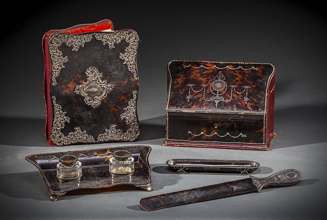 EDWARDIAN SILVER AND PIQUE TORTOISESHELL DESK SET: EDWARDIAN SILVER AND PIQUE TORTOISESHELL DESK SET Late 19th century Comprised of a slant front letterbox opening to a slotted interior, the exterior in red Moroccan leather. The standish of serpentine