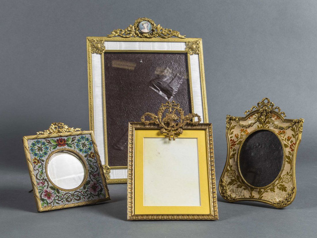 FOUR OLD WORLD STYLE GILT METAL PICTURE FRAMES: FOUR OLD WORLD STYLE GILT METAL PICTURE FRAMESEarly 20th century The largest rectangular frame with applied Neoclassical style mounts, the central crest incorporates a painted female portrait; another
