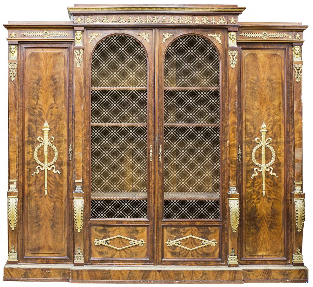 FINE CHARLES X ORMOLU MOUNTED MAHOGANY BIBLIOTHEQUE: FINE CHARLES X ORMOLU MOUNTED MAHOGANY BIBLIOTHEQUECirca 1830 Of slight breakfront outline, fitted with a pair of doors with inset with ormolu mounted panels beneath arched grills, opening to shelves,