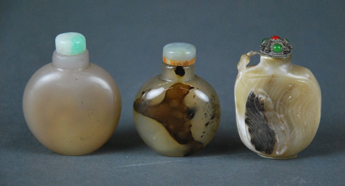THREE CHINESE CARVED SNUFF BOTTLES: THREE CHINESE CARVED SNUFF BOTTLES Comprising two fine agate examples well hollowed with rounded shoulders and a rare mother of pearl example. Height of tallest 6 cm