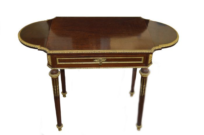 NO RESERVE FINE BRZ MOUNTED TABLE 19TH CENTURY: LOUIS XVI STYLE GILT BRONZE MOUNTED MAHOGANY WORK TABLE Late 19th century, the rectangular top with hinged flaps each with a border in bronze cast with a stylized egg-and-dart, the frieze with a drawe