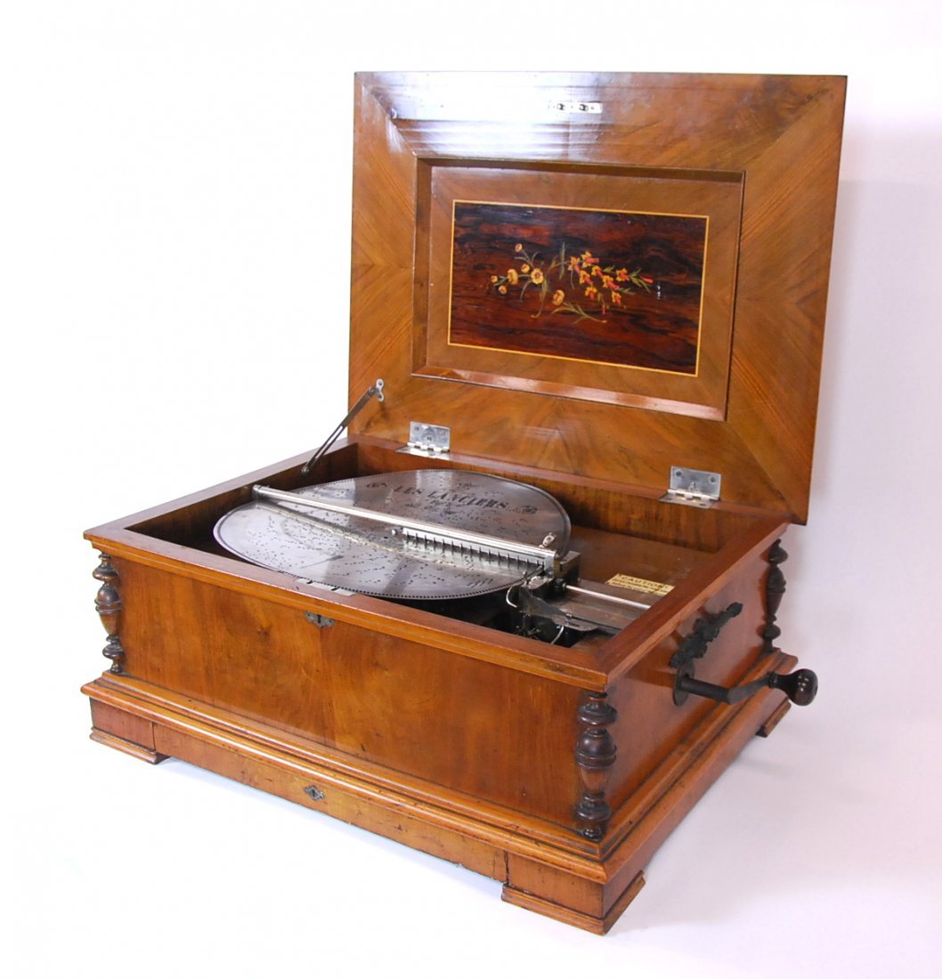 STELLA 17 IN. DISC MUSIC BOX, INLAID WALNUT, 19TH C: STELLA BREVETE 17 INCH DISC INLAID WALNUT MUSIC BOX Swiss, circa 1875, the rectangular molded case with a marquetry panel on the underside of the lid, engaged stiles and bronze carrying handles, with