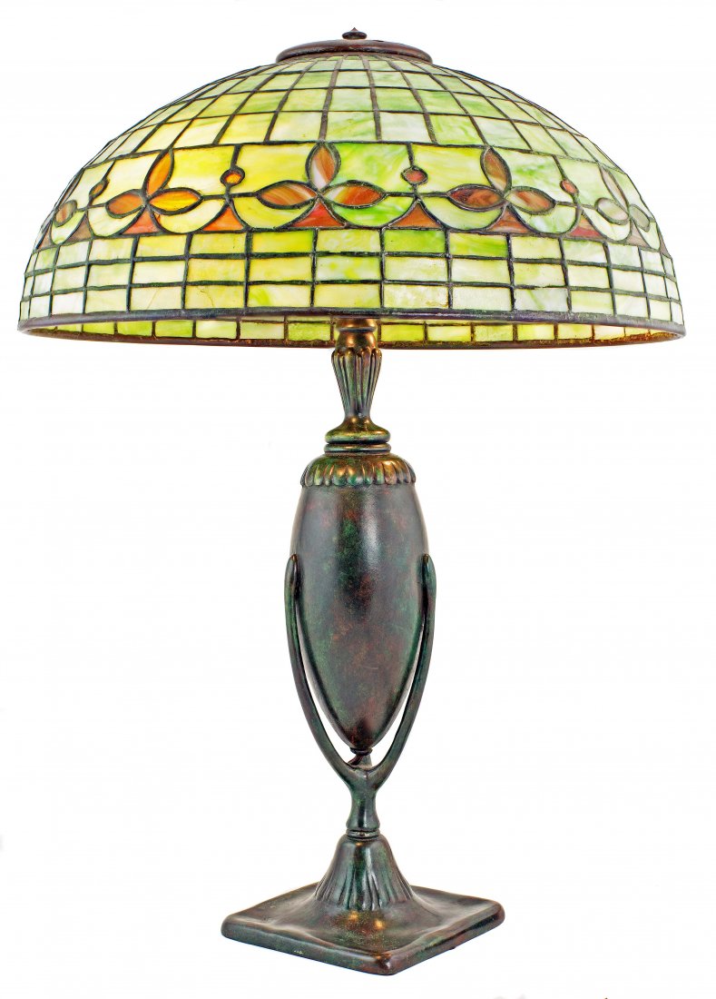 TIFFANY STUDIOS 1899-1920: A TIFFANY FAVRILE GLASS AND BRONZE 'FLEUR DE LIS' TABLE LAMP 1899-1920 greenish brown patina, has finial, shade impressed TIFFANY STUDIOS NEW YORK Height 20.5 in. (61.25 cm.), Diameter 16 in. (40 cm.)