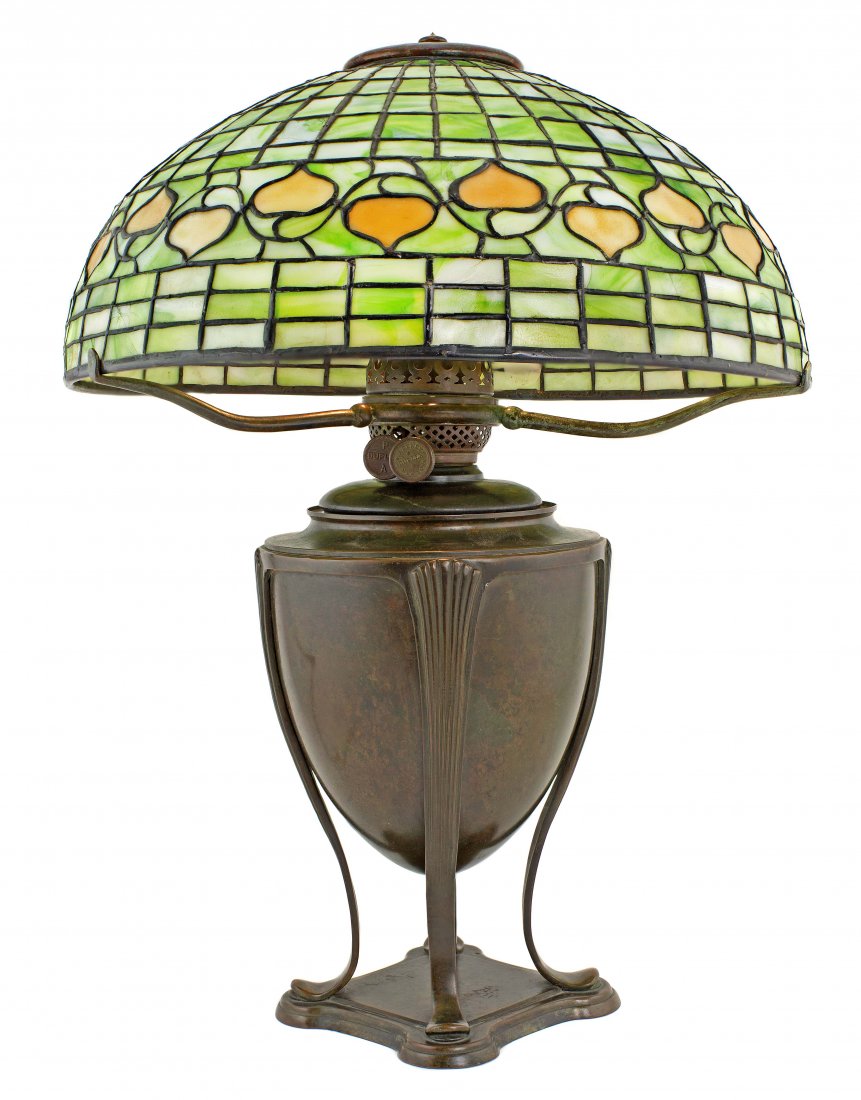 TIFFANY STUDIOS 1899-1920: A TIFFANY FAVRILE GLASS AND BRONZE 'LEAF AND VINE' TABLE LAMP ON AN OIL CAN BASE 1899-1920 rich brown patina, has finial, shade impressed TIFFANY STUDIOS NEW YORK,oil can impressed TIFFANY STUDIOS NEW
