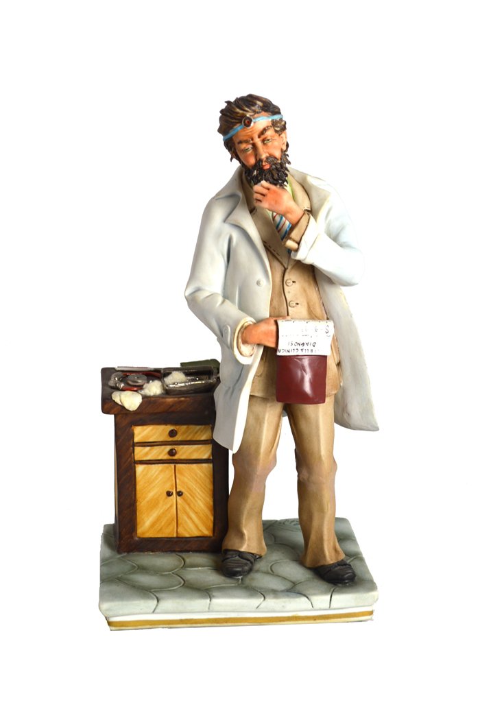 NO RESERVE, ITALIAN CAPODIMONTE PORCELAIN DOCTOR: NO RESERVE CAPODIMONTE PORCELAIN FIGURE OF A DOCTOR Modern, the Italian figure standing before a cabinet contemplating a document. Height 13 in. (32.5 cm)