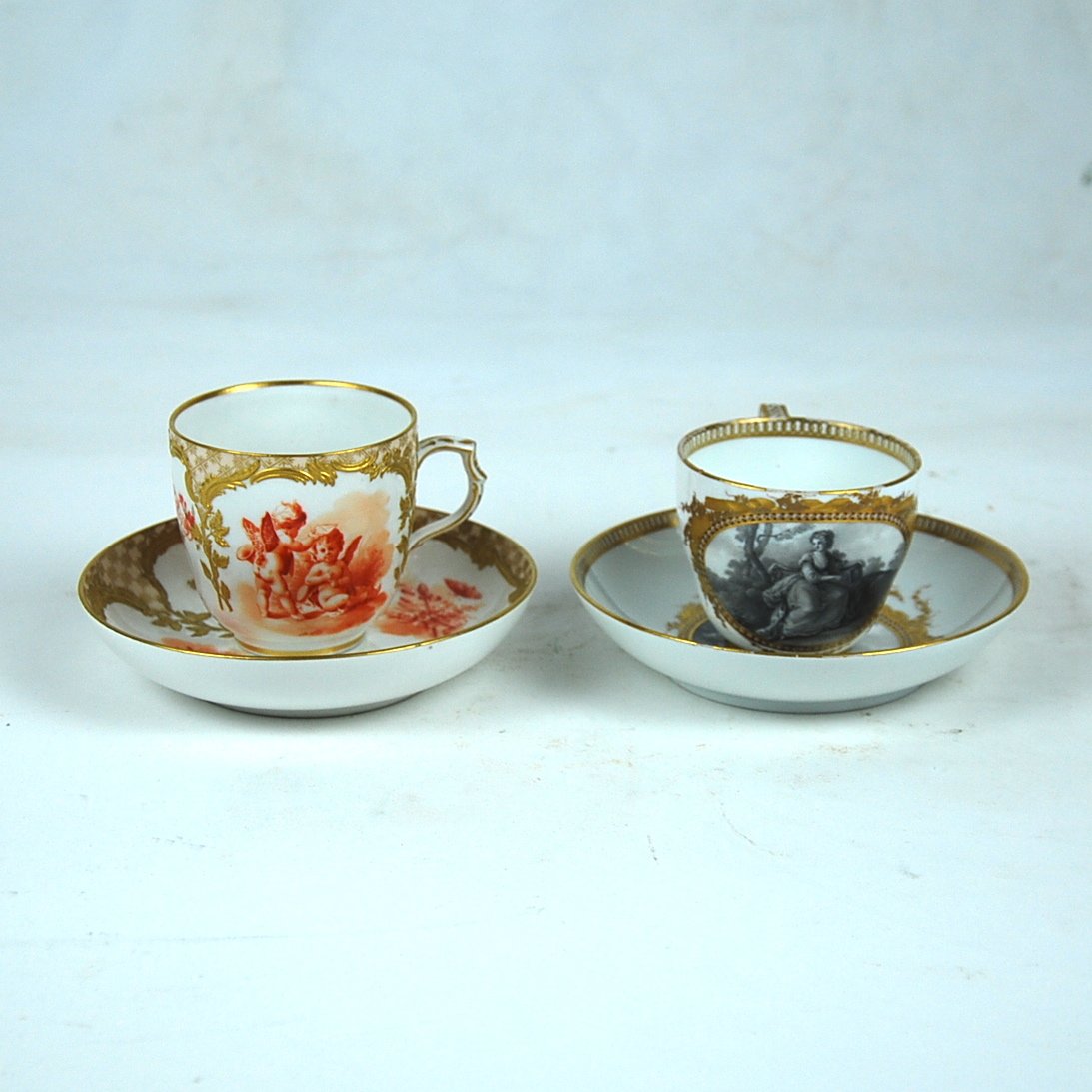 2 PORCELAIN CUPS & SAUCERS: KPM, VIENNA & MEISSEN, 19TH: VIENNA KPM AND A MEISSEN PORCELAIN CUP AND SAUCER 19th century, the underside of each cup and saucer respectively, with scepter and crossed swords in under glaze bue,; the first decorated with putti a