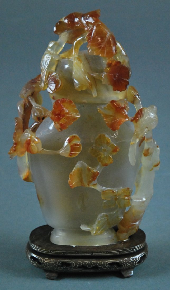 LARGE CARNELIAN AGATE VASE AND COVER, CHINESE: A LARGE CARNELIAN AGATE VASE AND COVER CHINESE 20TH CENTURY The vase shaped urn and cover carved in high relief with birds on blossoming vines.The softly polished stone is of a pale brown-white color.