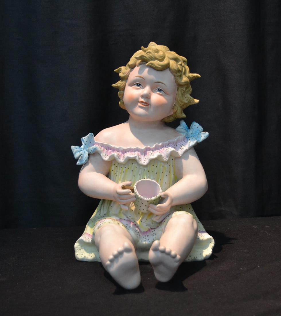 PAINTED BISQUE PORCELAIN PIANO BABY: 8" x 10" x 12 1/2"