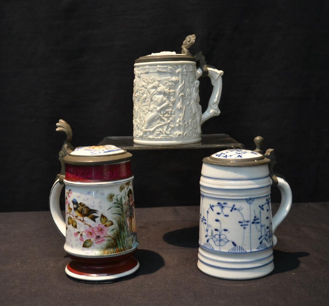 (3) PORCELAIN STEINS INCLUDING FIGURAL AMPHORA: (HAIRLINE) , BLUE & WHITE , HAND PAINTED STEIN DATED 1891 ; (2) HAVE LITHOPHANE SCENES - 3 1/2" x 5 1/2" x 8"