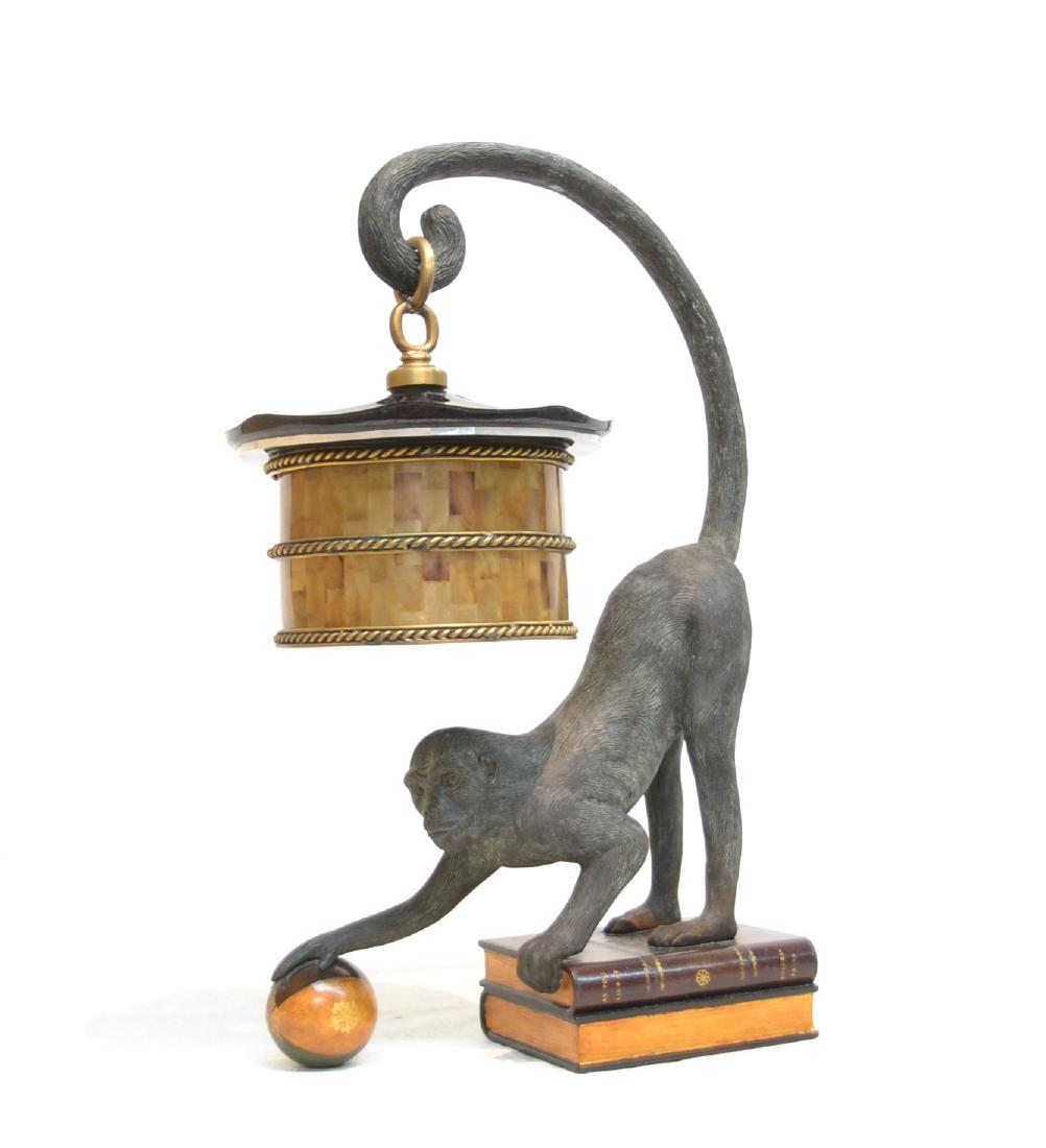 MAITLAND SMITH BRONZE MONKEY LAMP: MAITLAND-SMITH TABLE LAMP DEPICTING MONKEY STANDING ON BOOKS WHILE HOLDING BALL WITH MICA SHADE LANTERN SUSPENDED FROM TAIL - 14" x 6" x 24"