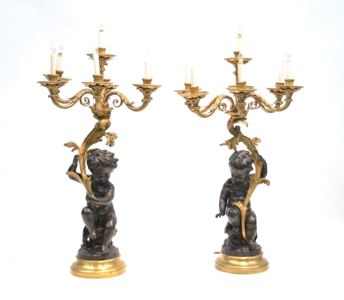 (Pr) LARGE CLODION , BRONZE CANDELABRAS: (Pr) LARGE PATINATED BRONZE PUTTIS HOLDING GILDED BRONZE BRANCH CANDELABRAS COMPRISING OF (8) LIGHTS ; SIGNED CLODION , ON BASE , AFTER MICHEL CLAUDE CLODION (1738-1814) 24" x 39" TO SOCKET