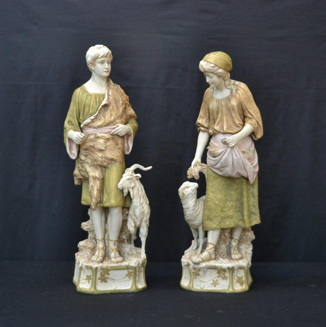 (Pr) LARGE ROYAL DUX FIGURES OF SHEPHERDS: (Pr) ROYAL DUX SHEPHERD & SHEPHERDESS WITH GOATS & LION CLOTH - 8" x 7" x 24" (ONE EAR RESTORED & ANTLER)