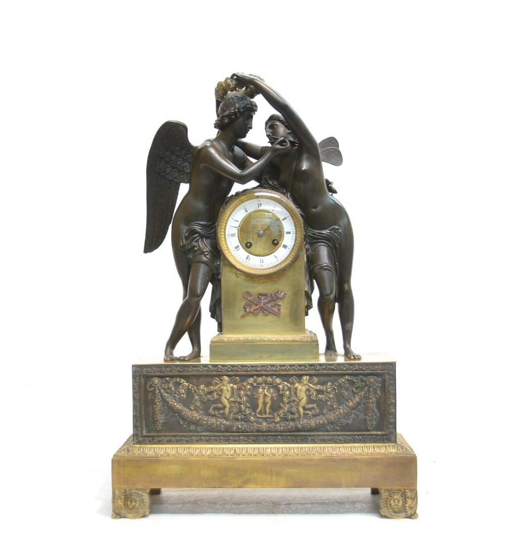FRENCH BRONZE CUPID & PSYCHE CLOCK: 2-TONE FRENCH BRONZE CLOCK DEPICTING PSYCHE PLACING CROWN ON CUPID ; WITH FIGURAL RELEIFS CUPIDS & LION MASKS ; AFTER SCULPTURE BY ANTONIO CANOVA - 16" x 5" x 24"
