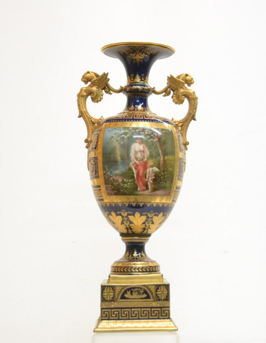 LARGE 19thC ROYAL VIENNA PORCELAIN VASE: WITH FIGURAL SCENES ON BOTH SIDES DEPICTING NYMPHE & AMOR ON ONE SIDE & GAROLEZ ? ; BOTH HAND SIGNED WAGNER , SURROUNDED BY HEAVY GOLD DECORATIONS OVER COBALT GROUND WITH WINGED CARYATID HANDLES - 9" 