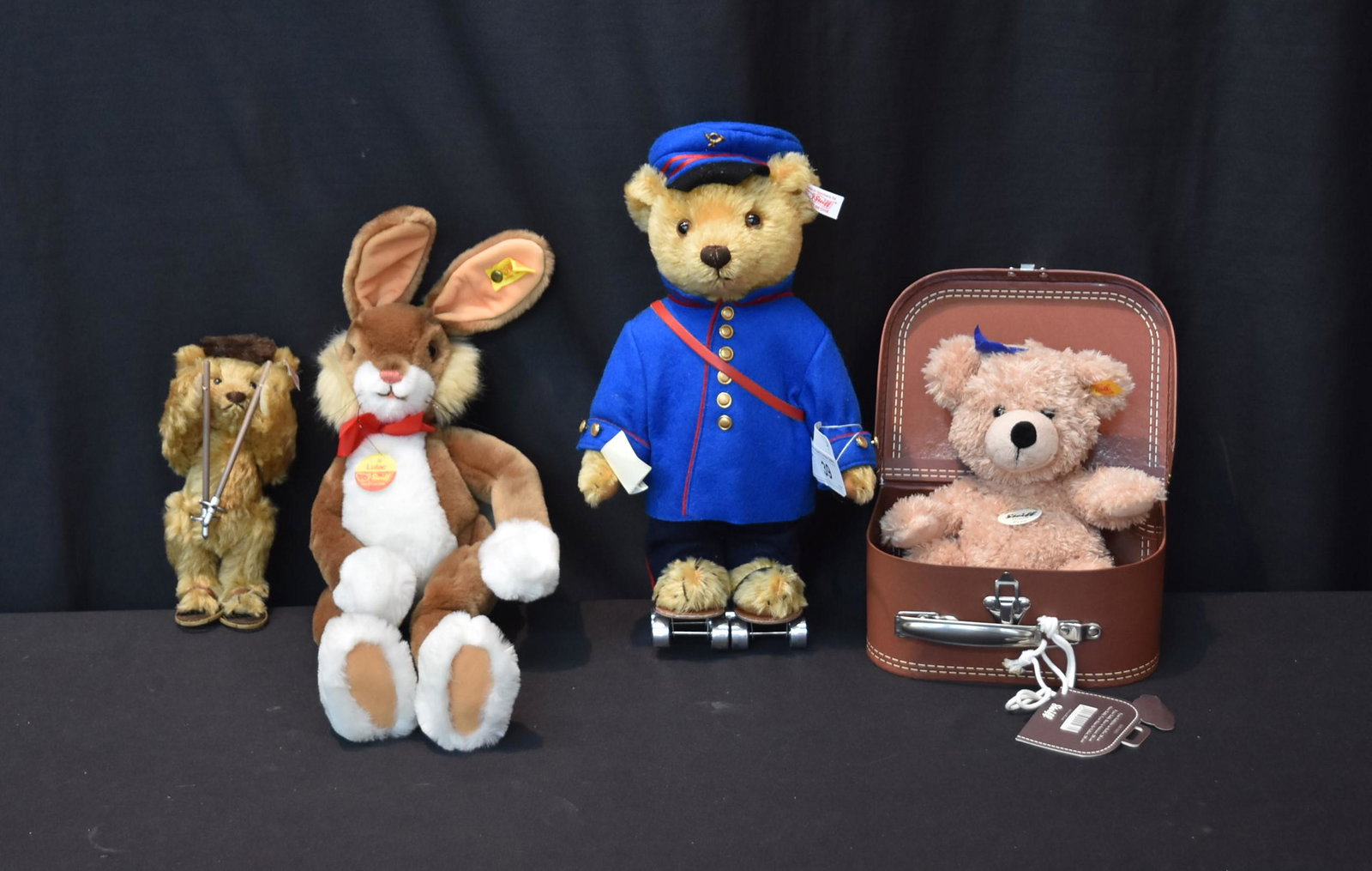 STEIFF BEAR GROUPING INCLUDING: STEIFF "FYNN" IN SUITCASE , STEIFF "LULAC" RABBIT , STEIFF "TELEGRAM" BEAR ON SKATES & STEIFF SKIER - LARGEST IS 14" TALL