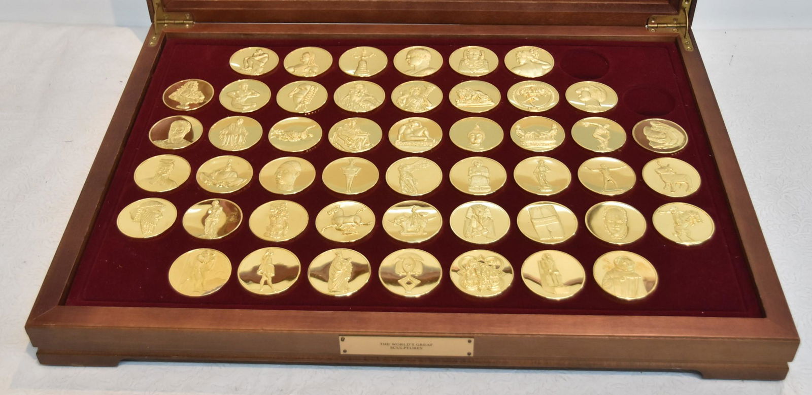FRANKLIN MINT "THE WORLDS GREAT SCULPTURES": FRANKLIN MINT 24kt GOLD PLATED BRONZE MEDALS OF WORLDS GREATEST SCULPTURES ; THIS SET IS MISSING (2) OF THE (50) MEDALS ; COINS ARE 2" ; 4oz EACH - SET IN PRESENTATION BOX - 23 1/2" x 17": x 3"