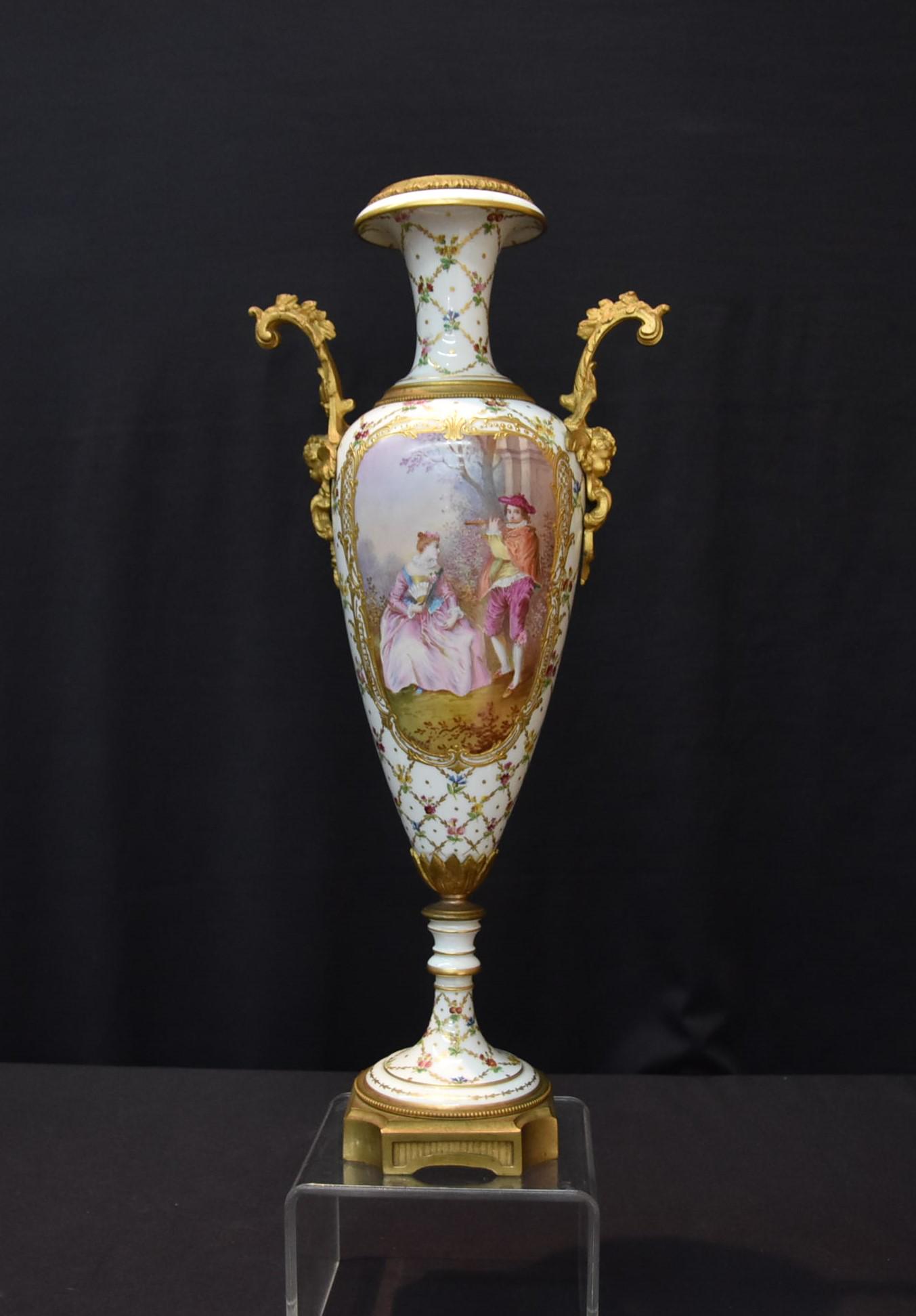 HAND PAINTED FRENCH SEVRES WHITE GROUND URN: HAND PAINTED WHITE GROUND SEVRES URN WITH ROMANTIC SCENE & LANDSCAPE MEDALLIONS , ARTIST SIGNED LACOSTE , SURROUNDED BY HAND PAINTED FLOWERS & FIGURAL BRONZE MOUNTS - 8 1/2" x 19"