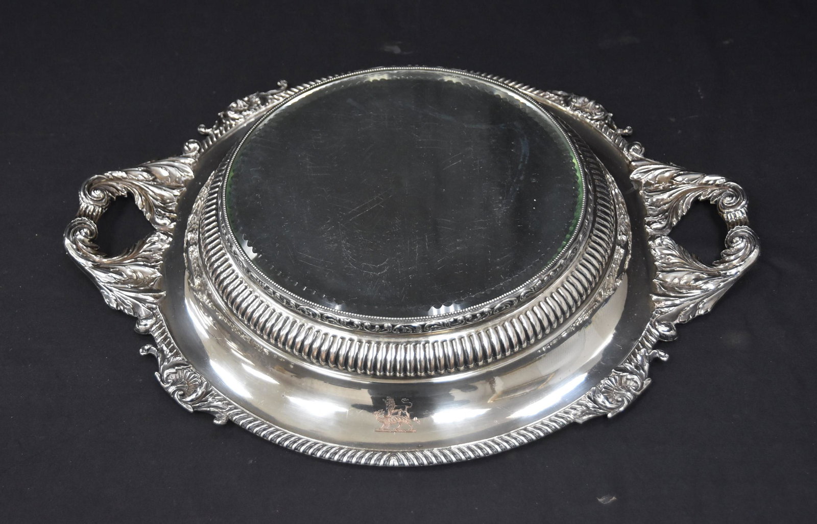 LARGE UNUSUAL TWIN HANDLE SILVER PLATE PLATEAU: LARGE SILVER PLATE TWIN HANDLE REFLECTOR PLATEAU WITH BEVELED GLASS MIRROR & HERALDIC CREST - 19" x 15" x 3" (SOME SCRATCHES TO MIRROR )