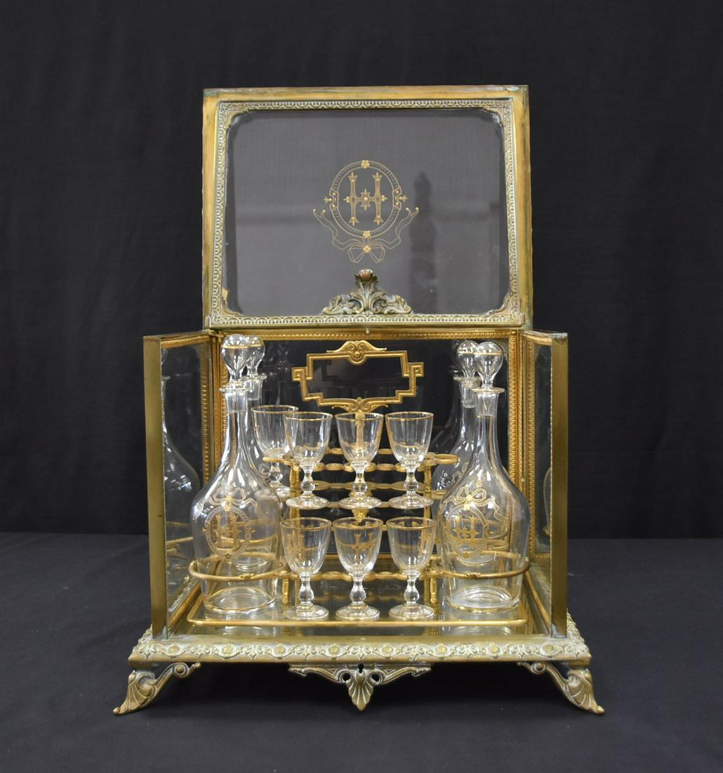 ANTIQUE BRONZE & GLASS TANTALUS SET: CUT GLASS TANTALUS BOTTLES , MONOGRAMMED H WITH CORDIAL GLASSES SET IN FITTED BASE HAVING BRONZE & GLASS CASE - 14" x 11" x 12" (MISSING SOME CORDIALS)