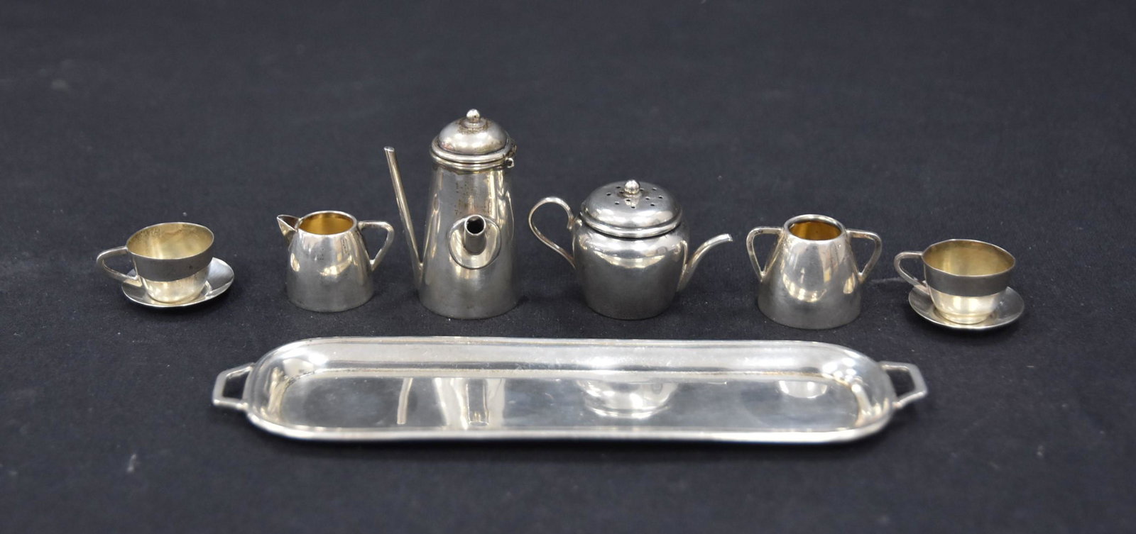 (7)pc MINIATURE SILVER TEA SET: INCLUDING TRAY , COFFEE POT , TEA POT , SUGAR , CREAMERS , (2) CUPS & SAUCERS - LARGEST PIECE IS 5" x 1 1/2" x 1 13/4" ; 48.1grams