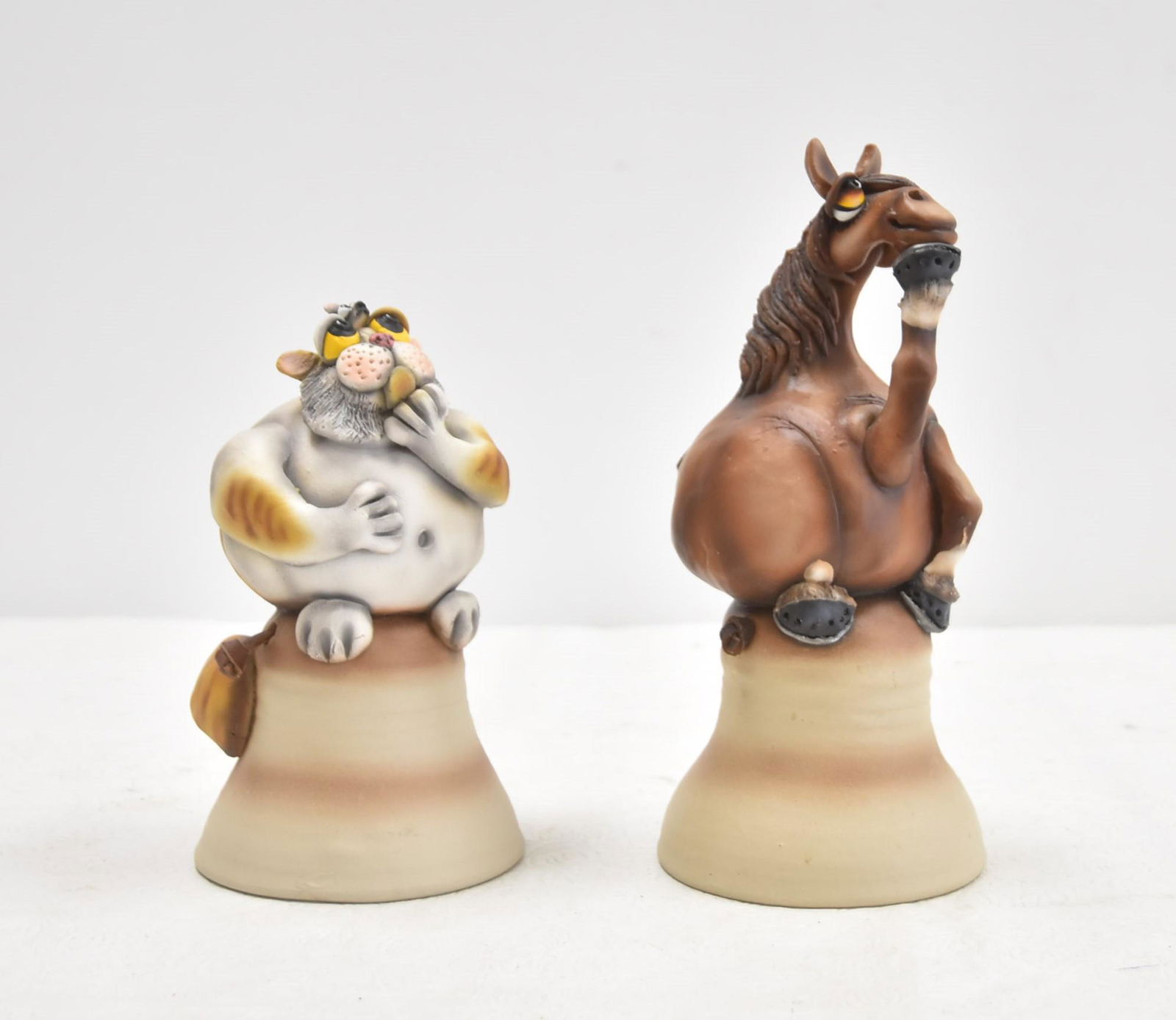 (2) TODD WARNER CERAMIC DINNER BELLS: (2) TODD WARNER WHIMSICAL CERAMIC DINNER BELLS OF HORSE & CAT SEATED ATOP BELL - 4" x 9 1/2"