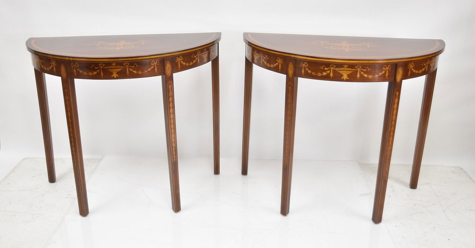 (Pr) INLAID EDWARDIAN STYLE CONSOLE TABLES: (Pr) MAHOGANY DEMILUNE CONSOLE TABLES WITH SATINWOOD INLAID BELL FLOWERS & URNS ; EDWARDIAN STYLE 35 1/2" x 18" x 29 1/2" (SOME MINOR SURFACE SCRATCHES ON TOP)