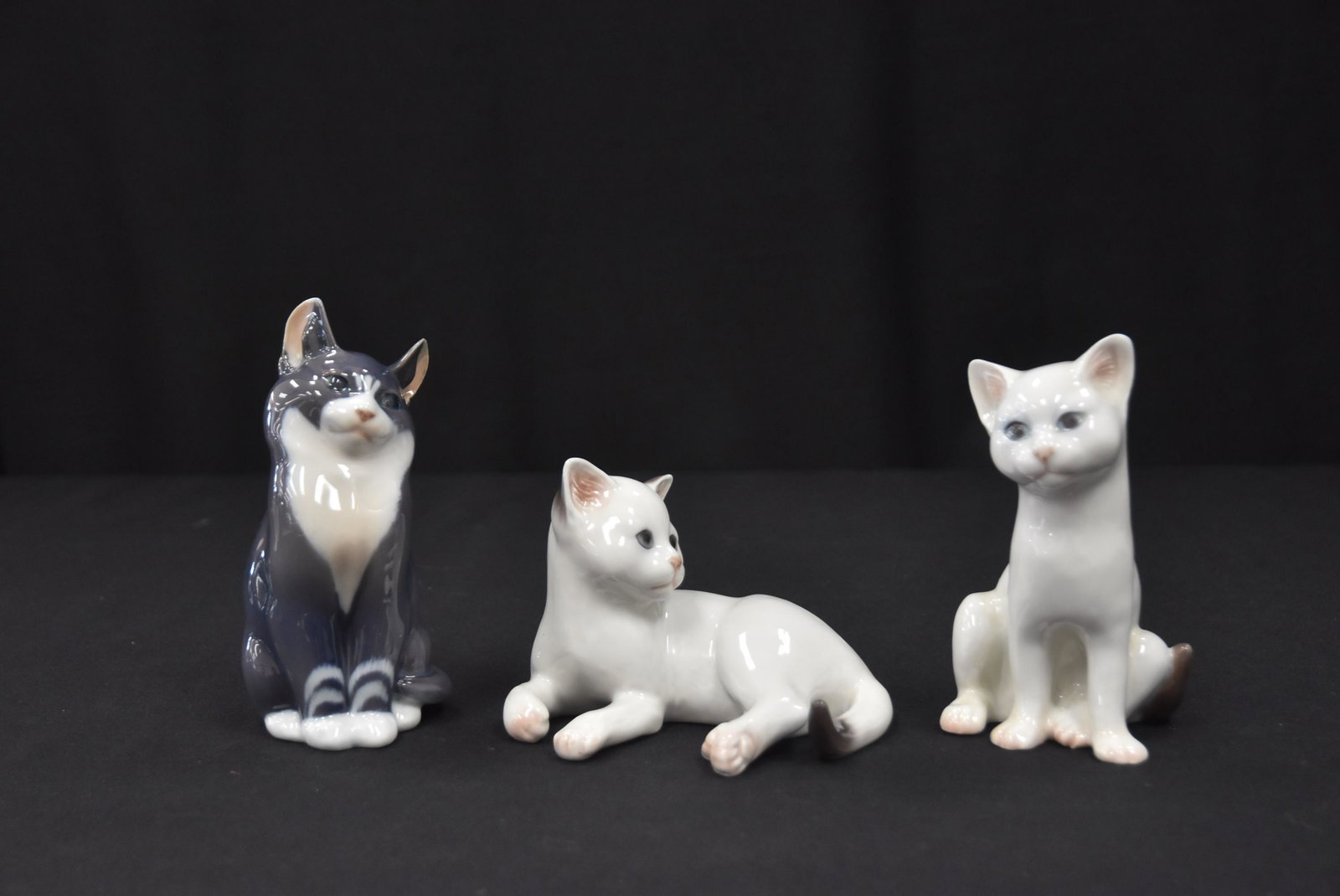 (3) ROYAL COPENHAGEN PORCELAIN CATS: ROYAL COPENHAGEN RECLINING CAT , MODEL 504 / ROYAL COPENHAGEN SEATED CAT , MODEL 505 , WITH BOX - LARGEST IS 3" x 5" / ROYAL COPENHAGEN PORCELAIN CAT , MODEL 115 - 2" x 2 1/2" x 5 1/2"