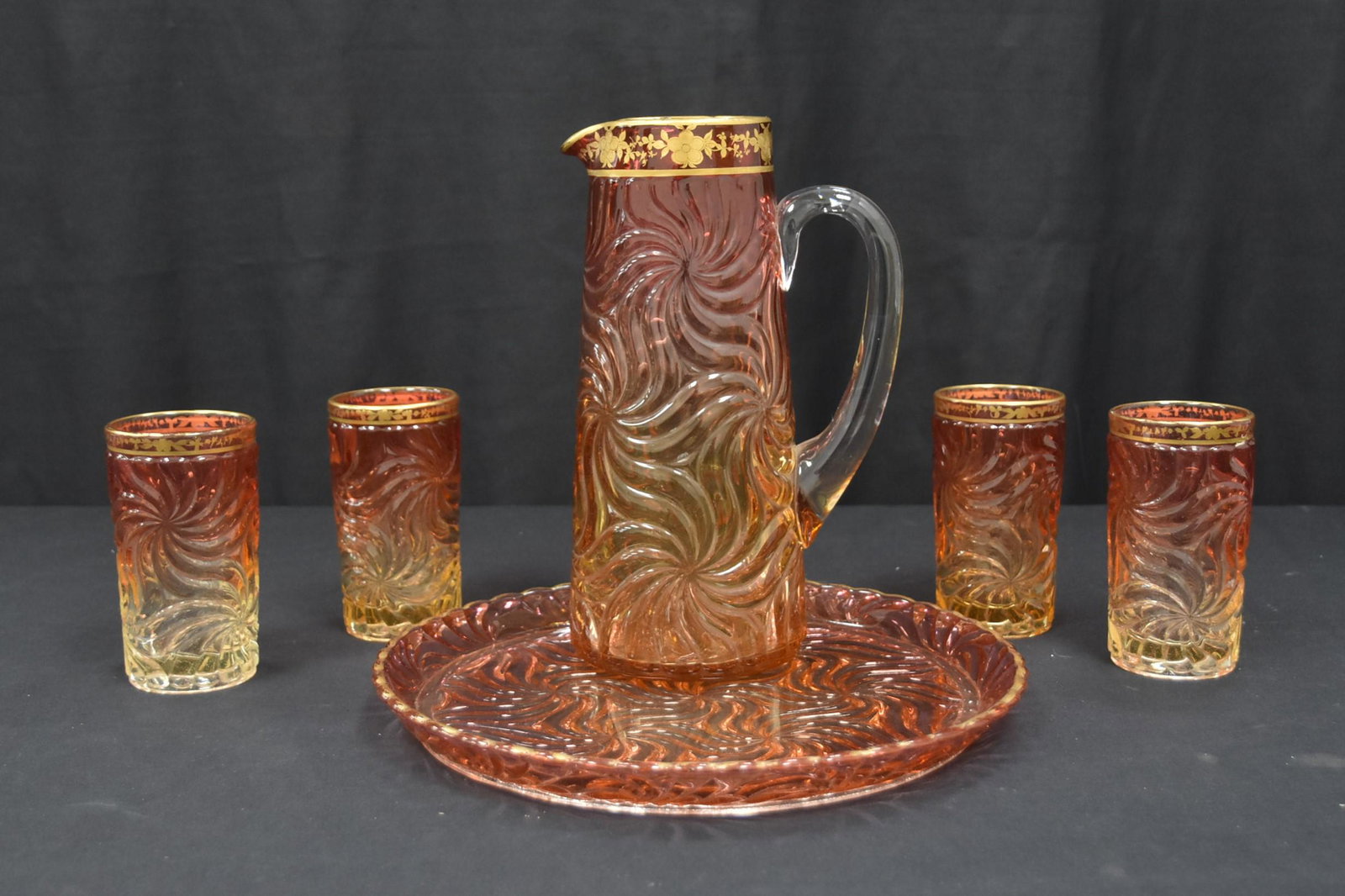 BACCARAT AMBERINA SWIRL LEMONADE SET: 19thC BACCARAT AMBERINA SWIRL LEMONADE SET CONSISTING OF PITCHER - 6" x 3 1/2" x 10" , (4) LEMONADE GLASSES - 4 3/4" & UNDERPLATE SIGNED BACCARAT / DEPOSE WITH GOLD DECORATIONS