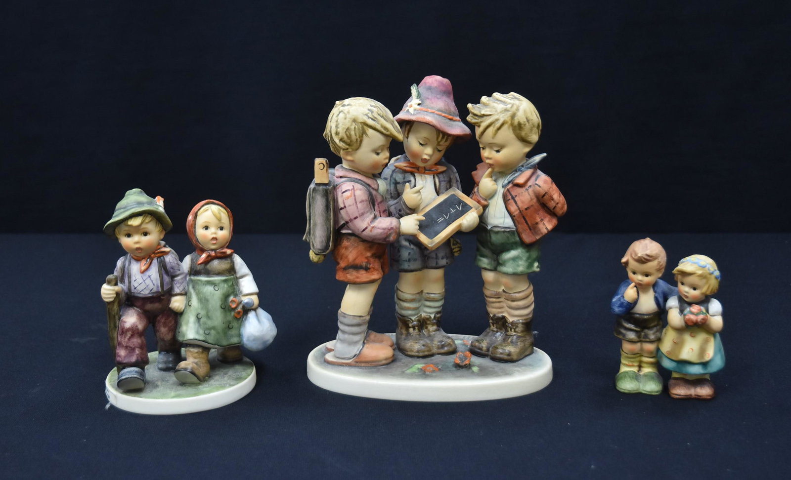 (3) HUMMEL FIGURINES: HUMMEL "SCHOOL BOYS" FIGURINE GROUPING (CHIP ON FEATHER OF BOYS CAP) - 6 1/2" x 3" x 7 1/2" / HUMMEL "GOING HOME" / HUMMEL "WE CONGRATULATE"