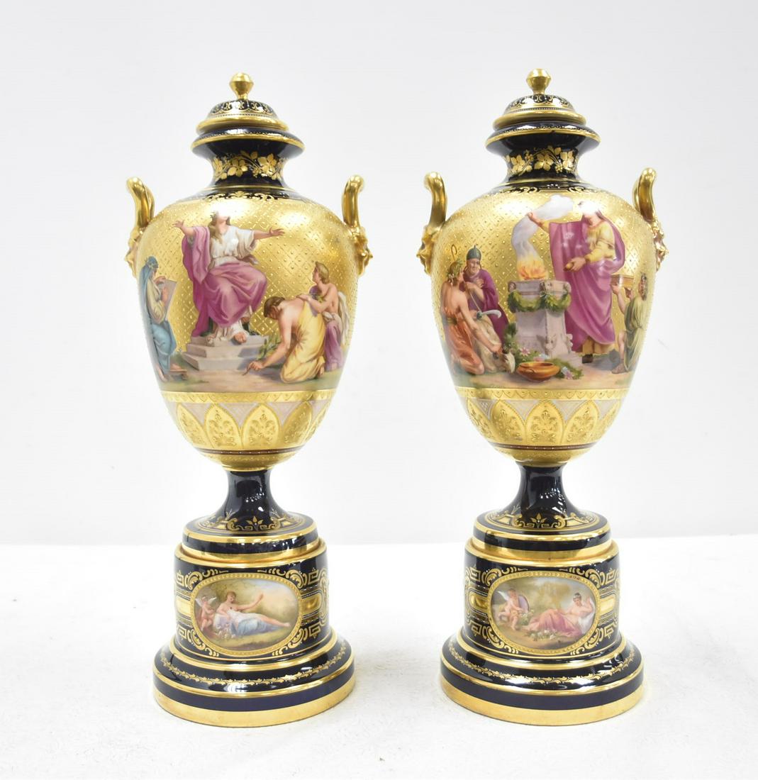 (Pr) ROYAL VIENNA MYTHOLOGICAL COVERED URNS: (Pr) ROYAL VIENNA STYLE COBALT & GOLD COVERED URNS WITH HAND PAINTED MYTHOLOGICAL SCENES ALL AROUND - 7" x 19" ; BEARING ROYAL VIENNA BEEHIVE MARK ; TITLES FADED