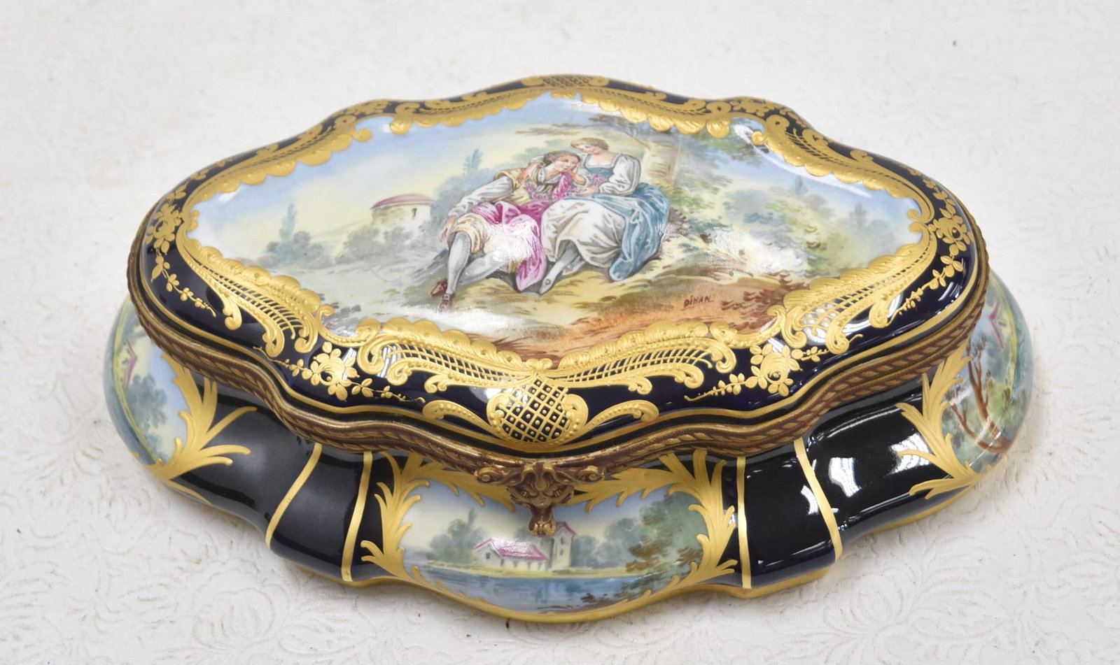 SEVRES CHATEAU de CHANTILLY DRESSER BOX: SEVRES CHATEAU de CHANTILLY BLEU LAPIS GROUND PORCELAIN DRESSER HINGED BOX WITH COURTING SCENE MEDALLIONS SURROUNDED BY LANDSCAPES ; ARTIST SIGNED; WITH HAND PAINTED FLORAL INTERIOR - 11 1/2" x 7" x 4