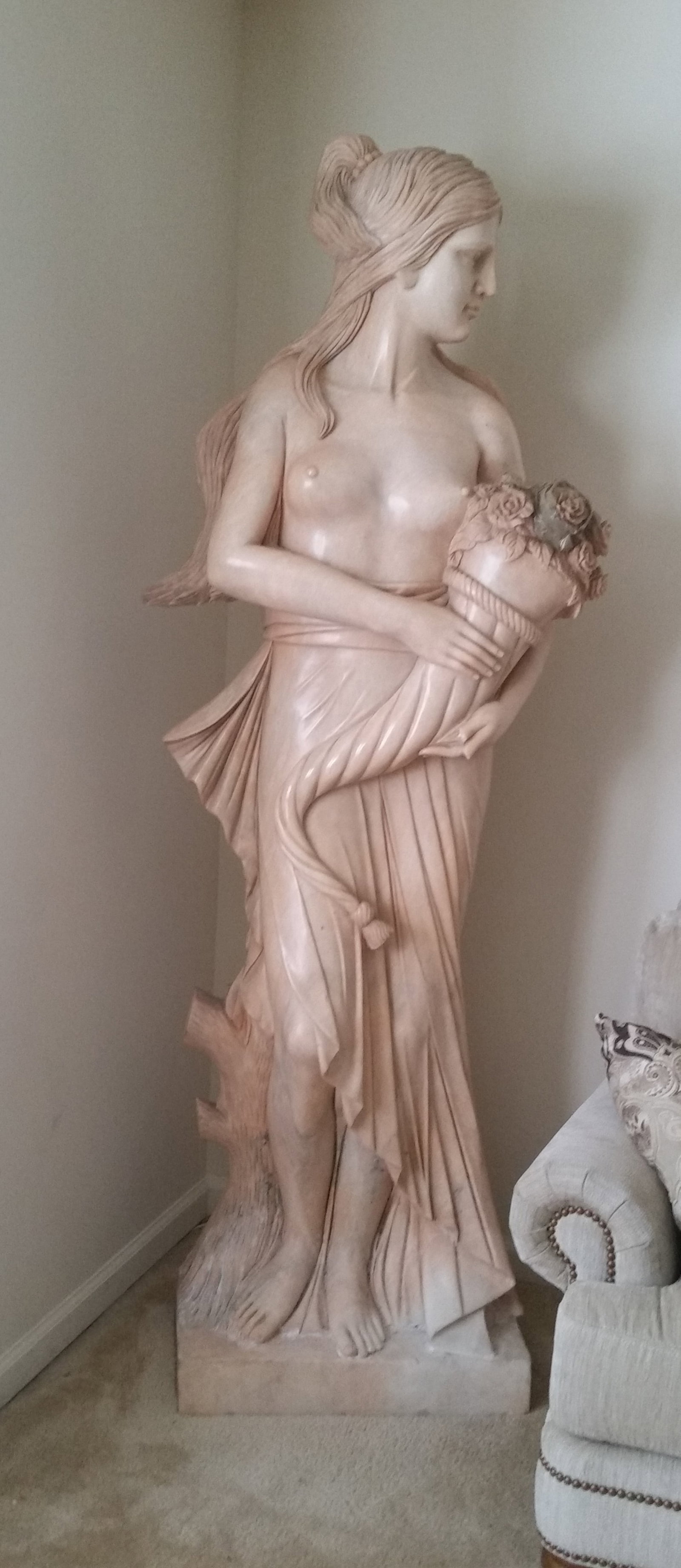 LARGE 6ft MARBLE WOMAN WITH CORNACOPIA: LARGE 6ft TALL PINK MARBLE SCULPTURE OF SEMI NUDE FEMALE MAIDEN HOLDING FLOWER CORNACOPIA - 30" x 30" x 75" (PLEASE NOTE THIS ITEM IS BEING SOLD OFF SITE ; BASIC DELIVERY FOR A FEE IS AVAILABLE BY OWN