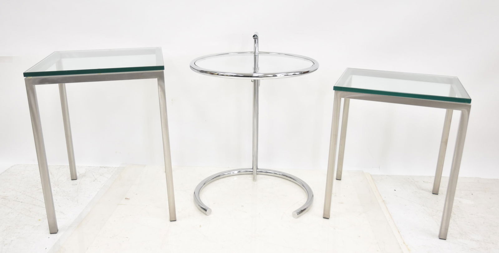 EILEEN GRAY ADJUSTABLE TABLE / (2) CHROME TABLES: ATTRIBUTED TO EILEEN GRAY , E 1027 ADJUSTABLE CHROME TABLE ; Eileen Gray Classicon E 1027 Adjustable Chrome & Glass Side Table - 20" X 27" / (2) CHROME PLATED STEEL & GLASS TABLES - 20" x 18" x 23"