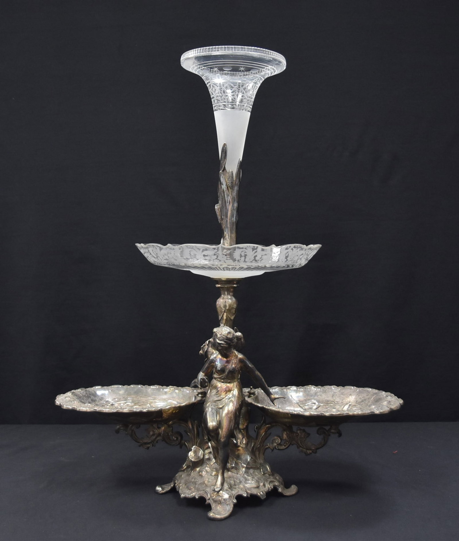 LARGE ART NOUVEAU SILVER PLATE EPERGNE: LARGE ART NOUVEAU SILVER PLATE & ETCHED GLASS EPERGNE WITH ART NOUVEAU SEMI NUDE MAIDEN SURROUNDED BY FLOWERS WITH ETCHED GLASS BOWL (HAS HAIRLINE) & ETCHED GLASS TRUMPET VASE - 20" x 7" x 24 1/2"