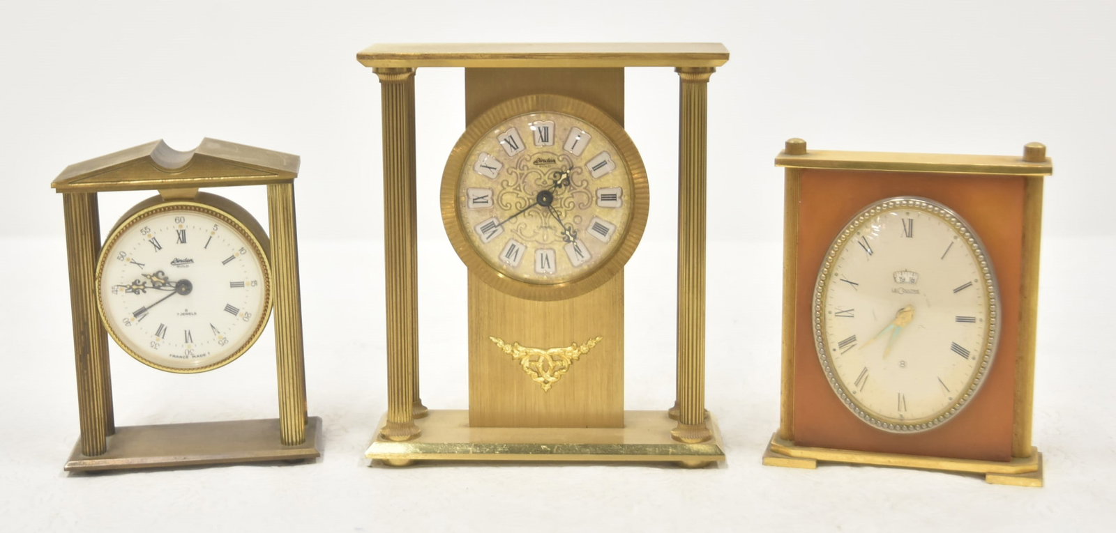 (3) VINTAGE DESK CLOCKS: LeCOULTRE ART DECO BRASS & BAKELITE DESK CLOCK / LYNDON BRASS ARCHITECTURAL DESK CLOCK - 4 1/2" x 2" x 5 1/2" / LYNDON GUILD ARCHITECTURAL DESK CLOCK WITH 7 JEWELS