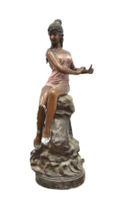LARGE BRONZE WOMAN SEATED ON ROCKS