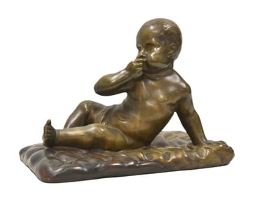 BRONZE BABY LAYING ON CARPET