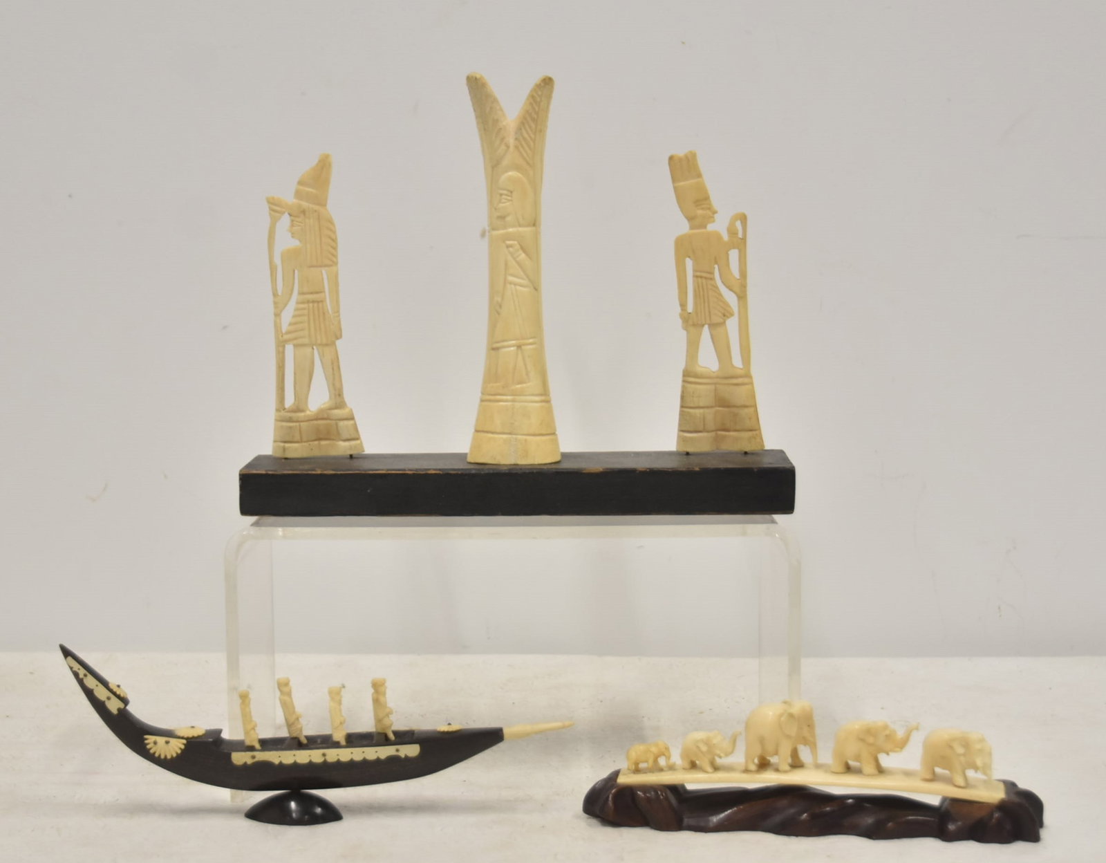 (3) ASSORTED BONE CARVINGS: EGYPTIAN PHARAOH 3-PART BONE CARVING / CARVED BONE ELEPHANT BRIDGE (NEEDS REPAIR) / CARVED BONE FIGURES ON ROW BOAT - LARGEST IS 10" x 2 1/2" x 8"