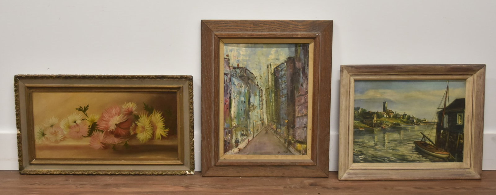 (3) OIL ON BOARD PAINTINGS: OIL ON BOARD CITY BUILDINGS STREET SCENE , SIGNED A. PIKE / OIL ON ARTISTS BOARD FLOWER STILL LIFE , UNSIGNED / OIL ON BOARD BOATS IN HARBOR , SIGNED BRAWIATH? - LARGEST 25" x 14"